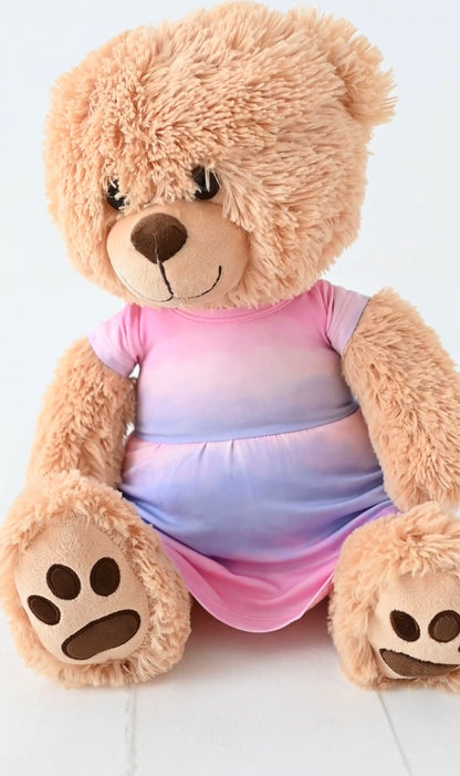 Plush teddy bear wearing a pink and purple bamboo dress on a white background