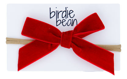 Red velvet bow hair accessory on a white background with 'birdie bean' branding.
