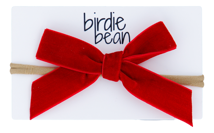 Red velvet bow hair accessory on a white background with 'birdie bean' branding.
