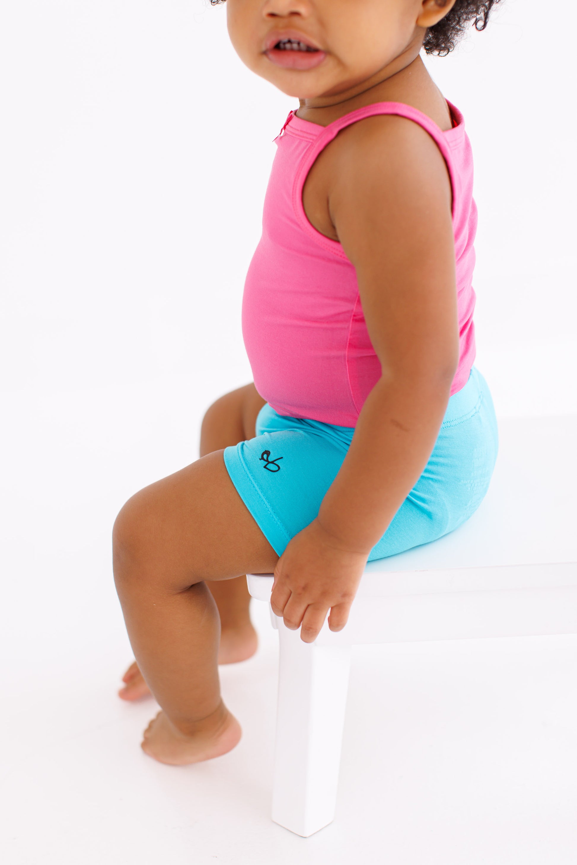 Baby wearing Scuba Biker Shorts styled with a pink tank top
