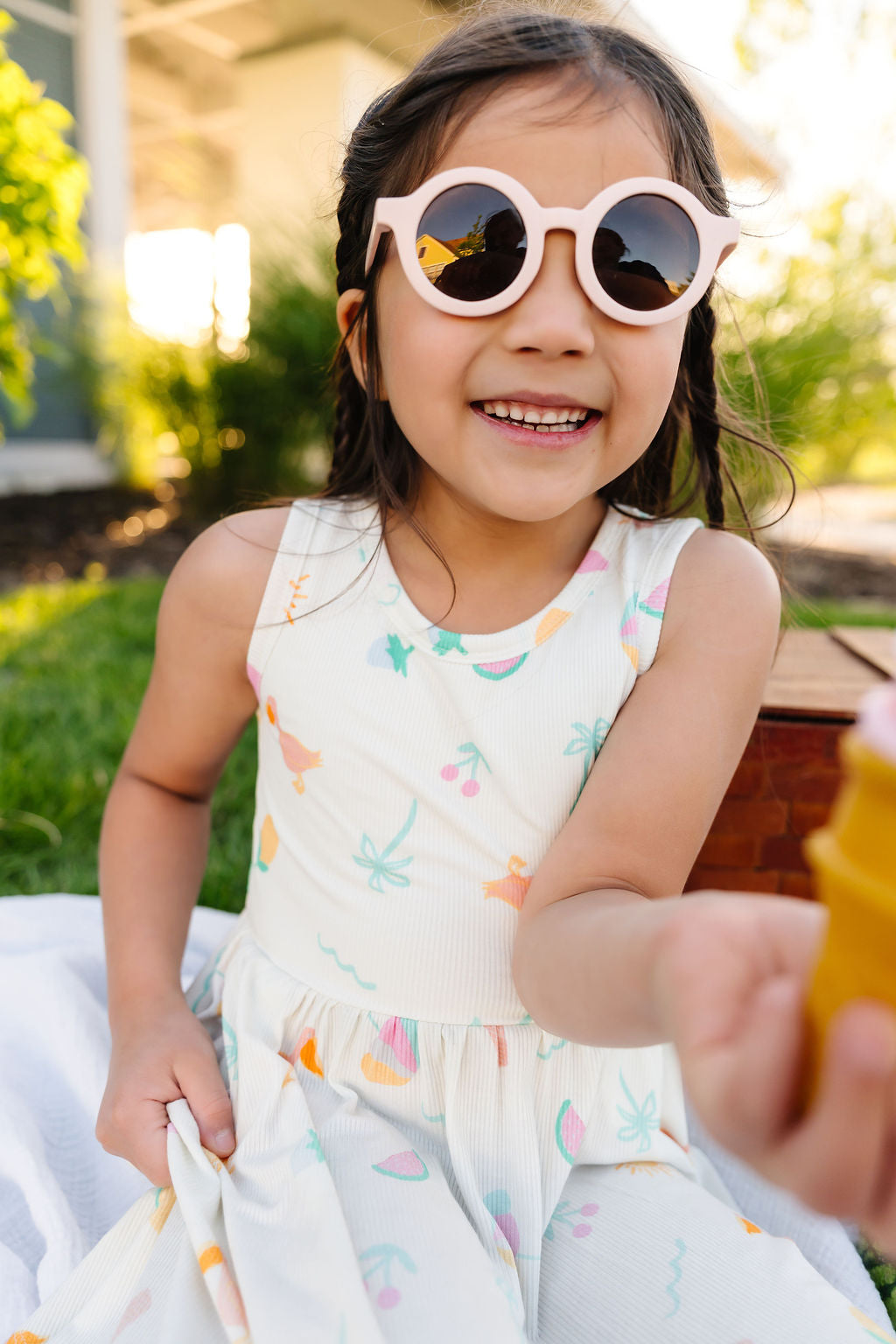 Young girl wearing sunglasses and a colorful dress outdoors