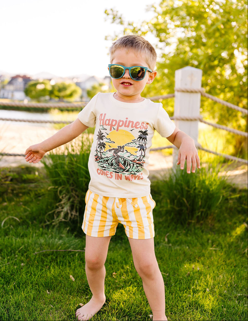 Child wearing sunglasses and a t-shirt with a graphic design outdoors