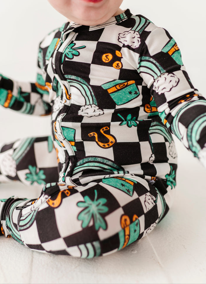 Close-up shot of a bamboo St. Patrick's Day themed convertible romper featuring top hats, four leaf colors, rainbows, and more!