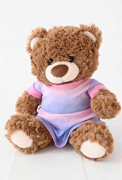 Brown teddy bear wearing a colorful bamboo dress on a white background