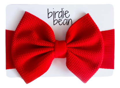 Red knitted bow on a white background with 'birdie bean' branding.